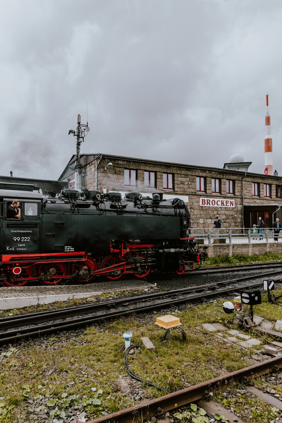 Historischer Dampfzug wartet auf einem steinernen Bahnsteig.